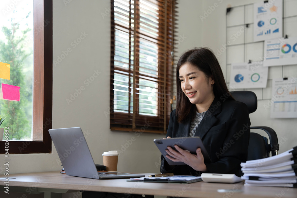 Asian Business woman using calculator and laptop for doing math finance on an office desk, tax, report, accounting, statistics, and analytical research concept Asian Business woman using calculator and laptop for doing math finance on an office desk, tax, report, accounting, statistics, and analytical research concept