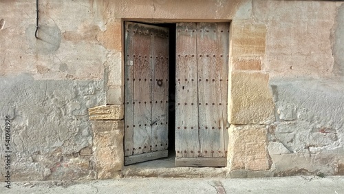 rustic wooden door open on old facade