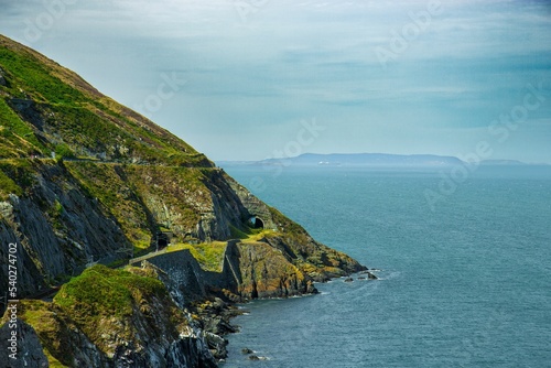 Beautiful rocky green cliffs over the water near Bray and Greystones in Ireland photo