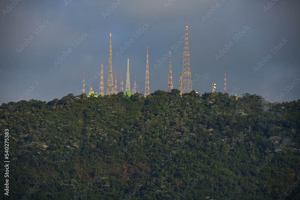 The radio masts and telecommunications towers at the top of Sumaré hill and above the dense, cloud-shrouded Atlantic rainforest of the Tijuca National Park, Rio de Janeiro, Brazil