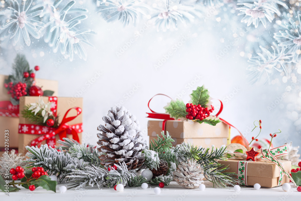 Christmas still life with gift boxes,snowy pine cones, baubles and fir branches on light background. Winter or Christmas festive concept. Christmas still life with gift boxes,snowy pine cones, baubles and fir branches on light background. Winter or Christmas festive concept.