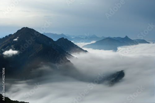 Blick vom Hochfelln auf Wolken und Hochgern bei Sonnenschein und Nebel