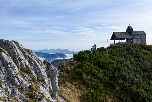 Blick vom Hochfelln  auf Wolken und Berge bei Sonnenschein mit Kapelle photo