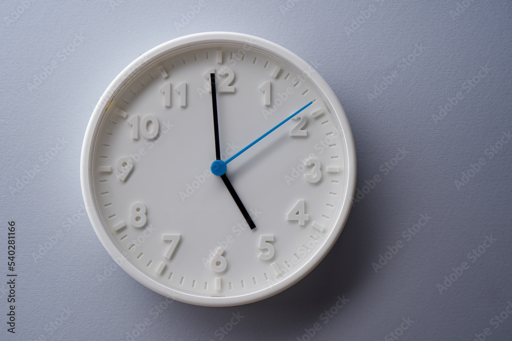 5 o'clock wall clock against gray background 5 o'clock wall clock against gray background