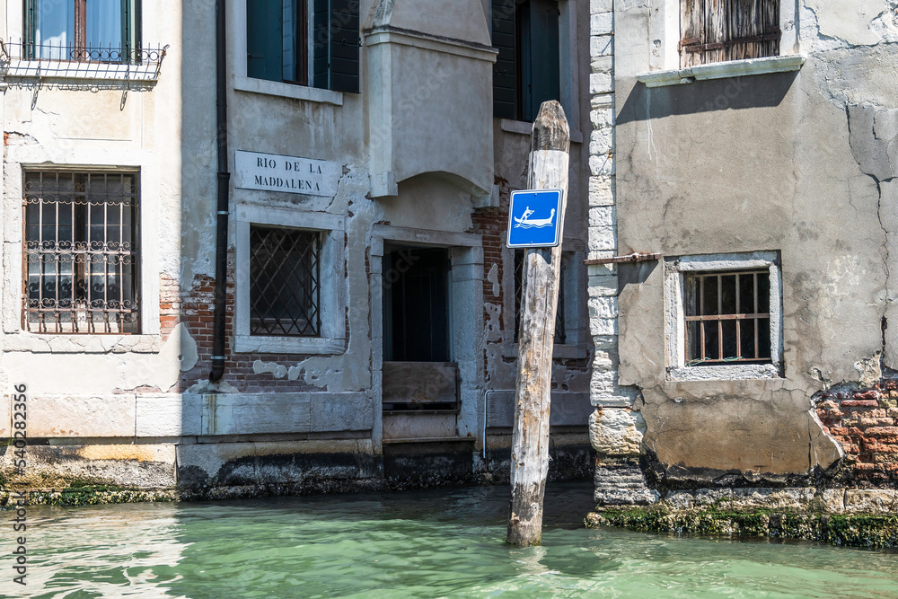 A wooden post, with a sign warning of Gondolas, in Venice.