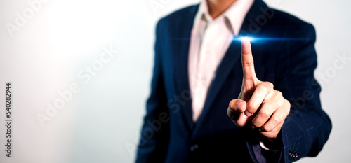 Businessman pressing button on blue light virtual screen. Man pointing on futuristic interface. Innovation technology internet and business concept. Space for text and words. Abstract background.