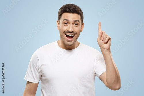 Man pointing up with finger feeling excited with open mouth, showing benefit of commercial offer