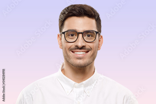 Young handsome smiling man wearing glasses and white shirt, isolated on purple background