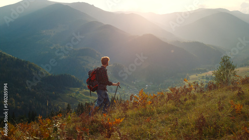 Active man walk mountains landscape. Sporty tourist hiking using trekking poles. © stockbusters