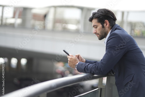 businessman using smartphone in city street.