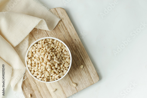 overhead view of pine nuts on a bowl on white 