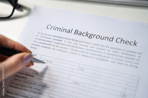 Human Hand Filling Criminal Background Check Application Form