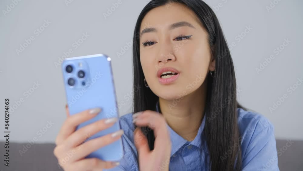 Beautiful Vietnamese girl speaking on frontal camera of smartphone. Pretty asian female talking with friends on video call. BIPOC person lifestyle video clip Beautiful Vietnamese girl speaking on frontal camera of smartphone. Pretty asian female talking with friends on video call. BIPOC person lifestyle video clip
