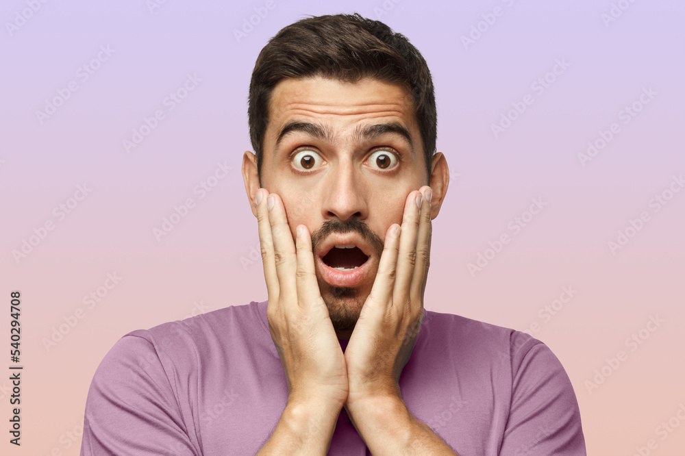 Man dressed in casual clothes, with round eyes, experiencing deep astonishment and fear Man dressed in casual clothes, with round eyes, experiencing deep astonishment and fear