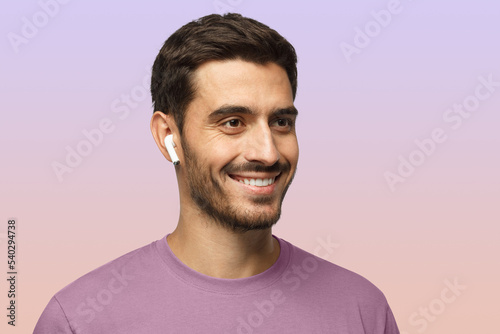 Close up headshot of smiling man wearing t-shirt, listeting to his favorite music track photo