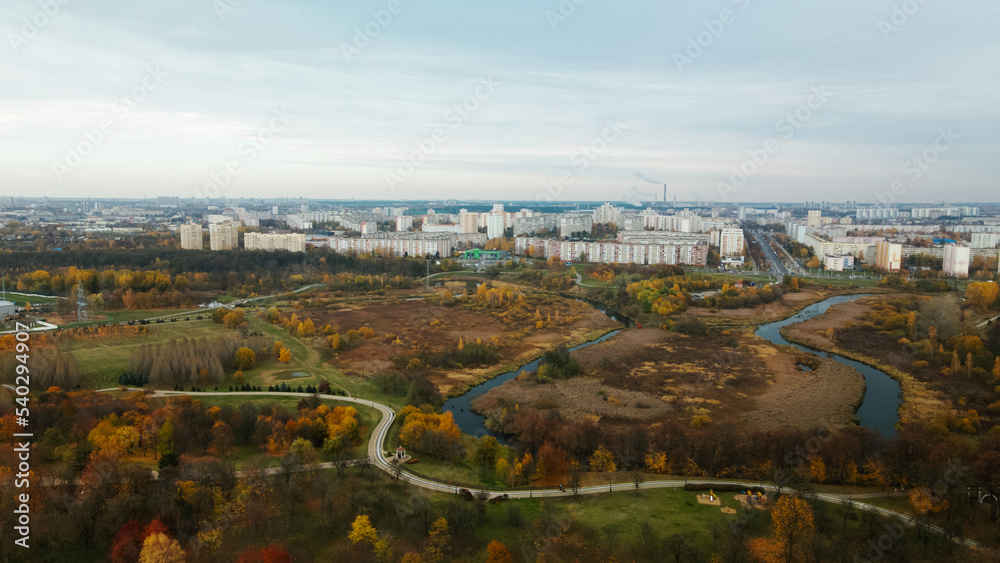 Autumn city park. Trees with colorful leaves. A cycle path winds between the trees. Autumn landscape. Aerial photography. Autumn city park. Trees with colorful leaves. A cycle path winds between the trees. Autumn landscape. Aerial photography.
