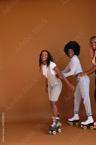 Studio portrait of young friend group on rollerskates
 photo