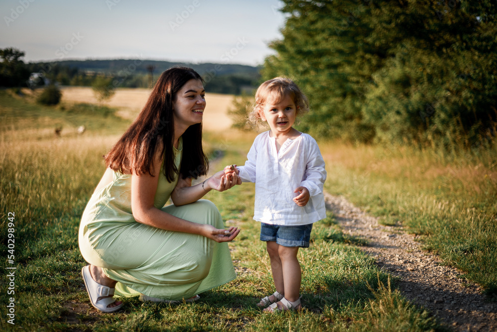 Fototapeta premium mother plays with her child in the evening park