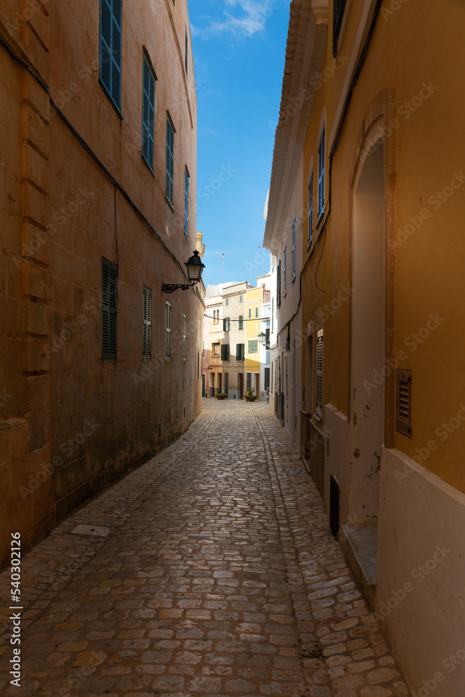 Obraz premium Calle estrecha del centro histórico de Ciutadella (Ciudadela) en Menorca. Callejón adoquinado del centro de la ciudad.