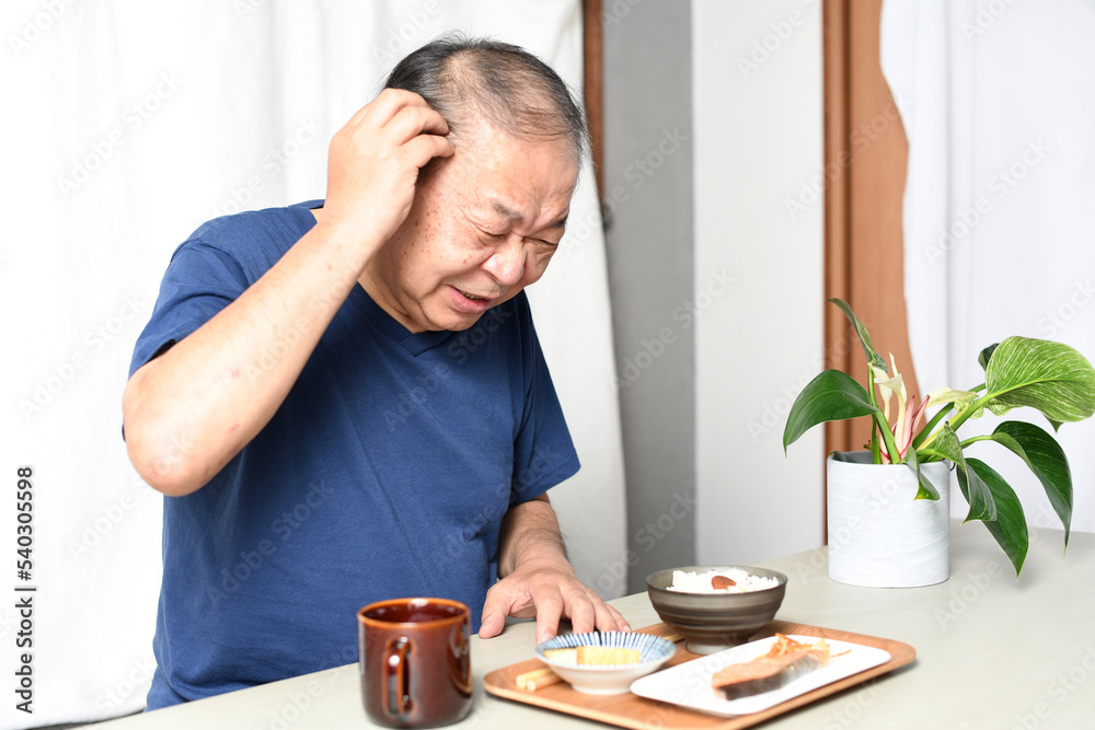 食事の前で困る高齢者のシニア男性