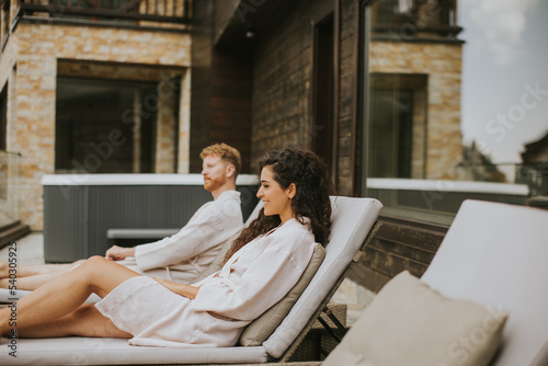 Young couple relaxing on beds on the outdoor terrace