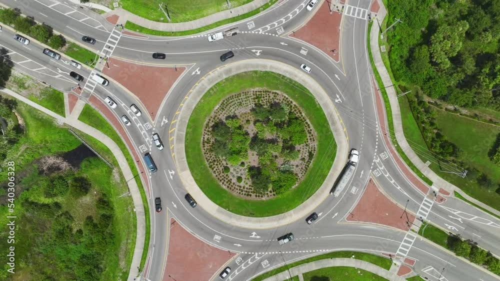 Aerial view of road roundabout intersection with fast moving heavy traffic. Urban circular transportation crossroads Aerial view of road roundabout intersection with fast moving heavy traffic. Urban circular transportation crossroads