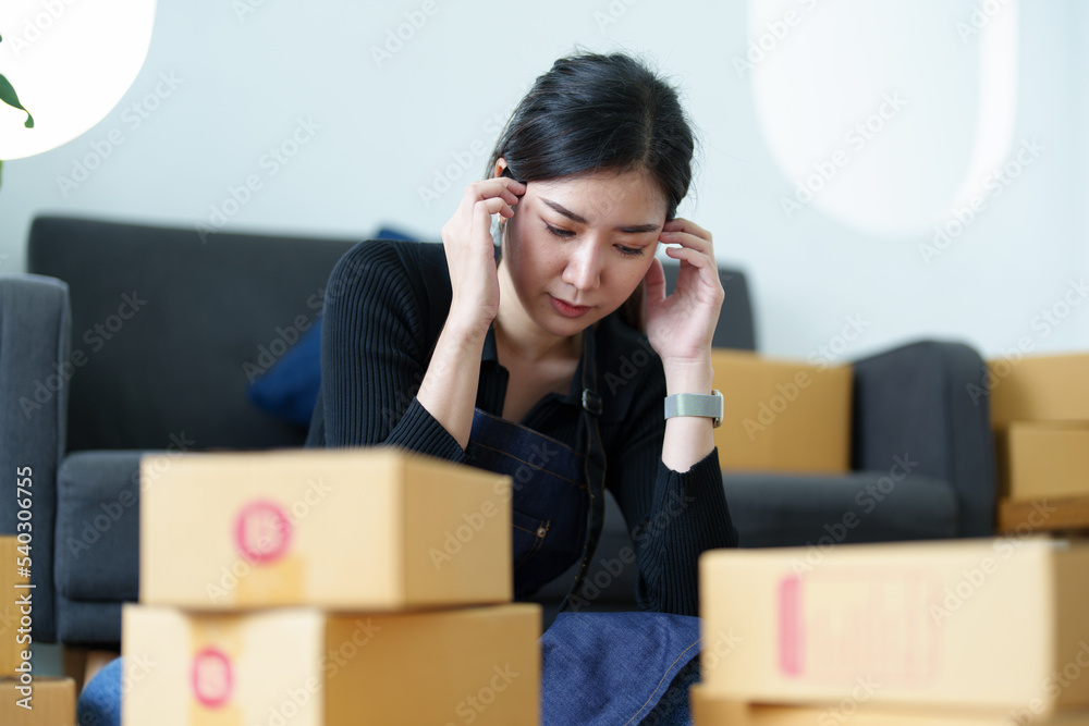 Startup small business entrepreneur of independent young Asian woman using uncheerful unsuccessful laptop computer of online marketing package box items and SME delivery ideas. Startup small business entrepreneur of independent young Asian woman using uncheerful unsuccessful laptop computer of online marketing package box items and SME delivery ideas.