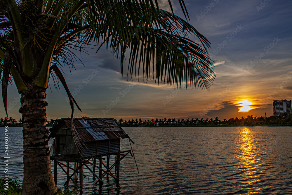 Fototapeta premium sunset on the lake with the fishing deck at golden hour