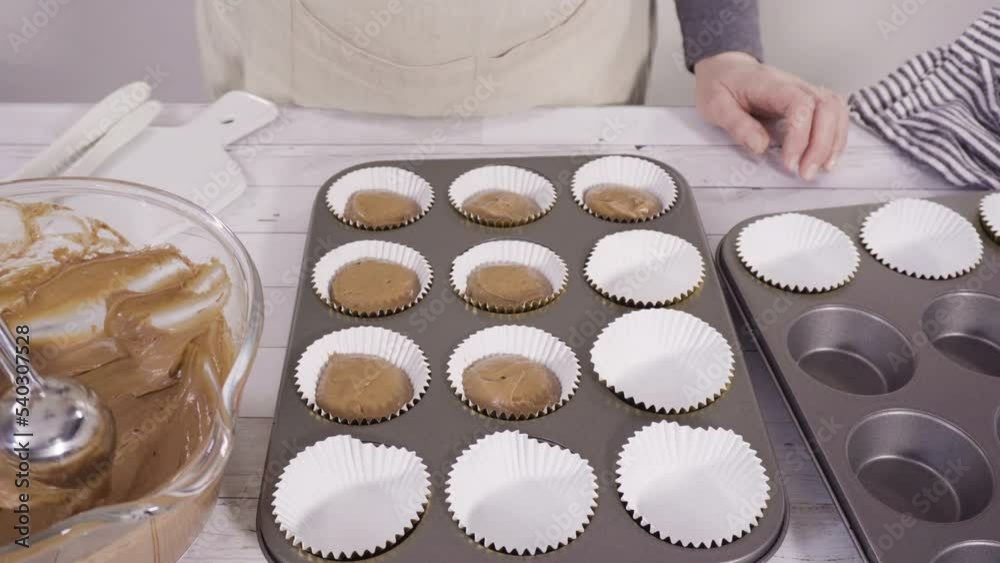 Scooping dough into the foil cupcake liners to bake chocolate raspberry cupcakes. Scooping dough into the foil cupcake liners to bake chocolate raspberry cupcakes.