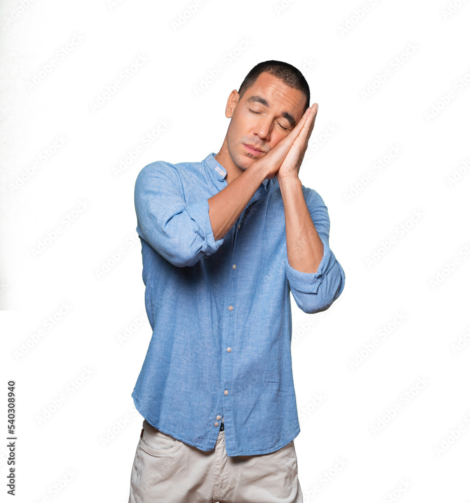 Relaxed young man making a gesture of sleep Relaxed young man making a gesture of sleep