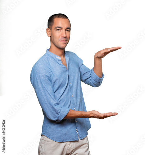 Confident young man doing a gesture of holding something with his hands