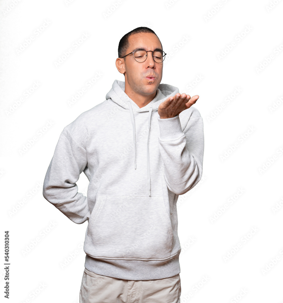 Friendly young man making a gesture of sending a kiss with his hand Friendly young man making a gesture of sending a kiss with his hand