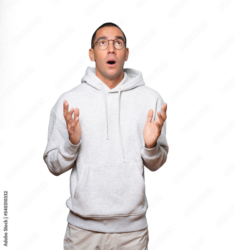 Happy young man looking up gesture