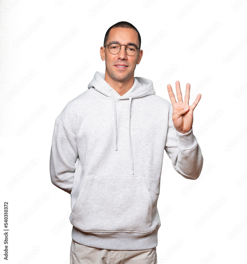 Young man making a number four gesture Young man making a number four gesture