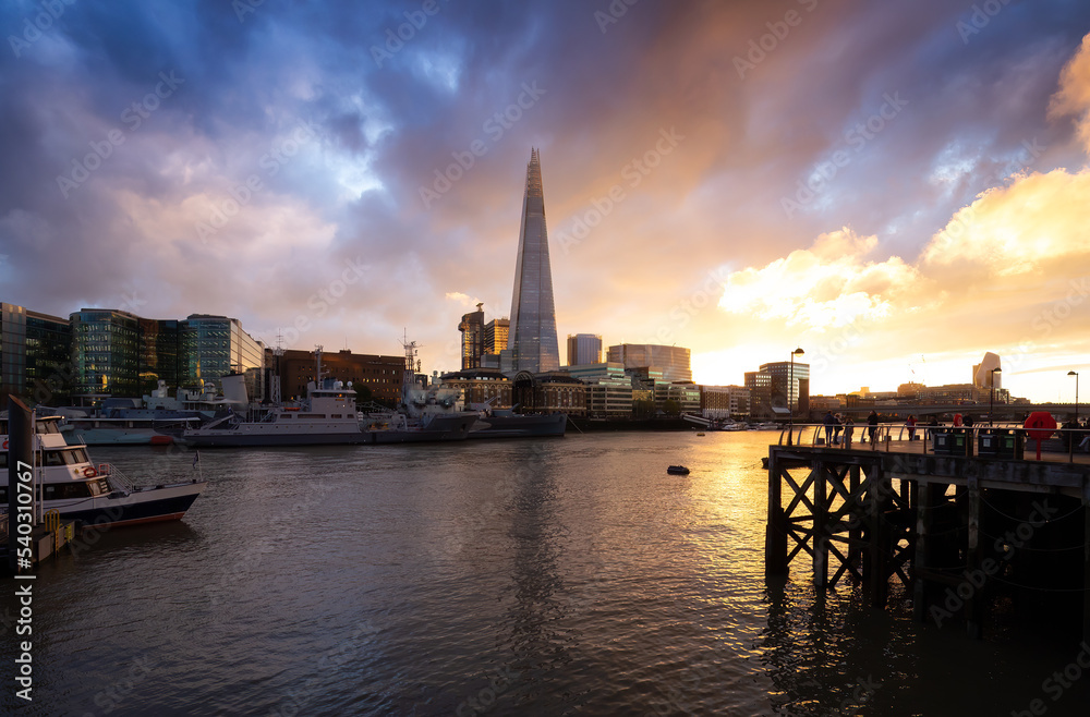 View of River Thames and City Skyline during dramatic sunset. City of London, United Kingdom. Travel Destination