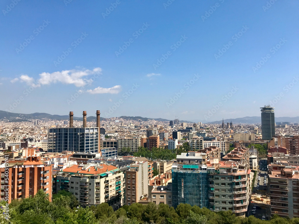 Barcelona, Spain, June 2019 - A view of a city with tall buildings in the background