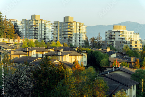 Aerial view of fall colors at the BC residential community of UniverCity Highlands on Burnaby Mountain, BC, with mountains in background partially obscured by smoke haze from nearby forest fires.