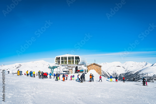 People, families, skiers and snowboarders taking off from ski lift and having fun in winter, El Tarter, Grandvalira, Andorra, Pyrenees Mountains