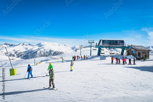 People, families, skiers and snowboarders exiting from ski lift on the top of the mountain. Winter in Andorra, El Tarter, Pyrenees Mountains