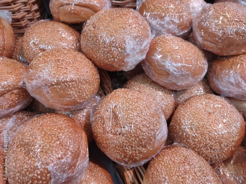 fresh ruddy delicious sesame buns in a basket on the bakery counter