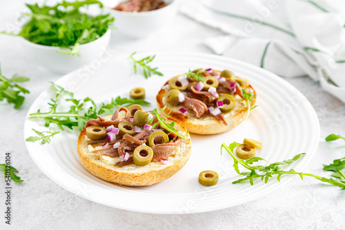 Anchovy toasts with olives and arugula