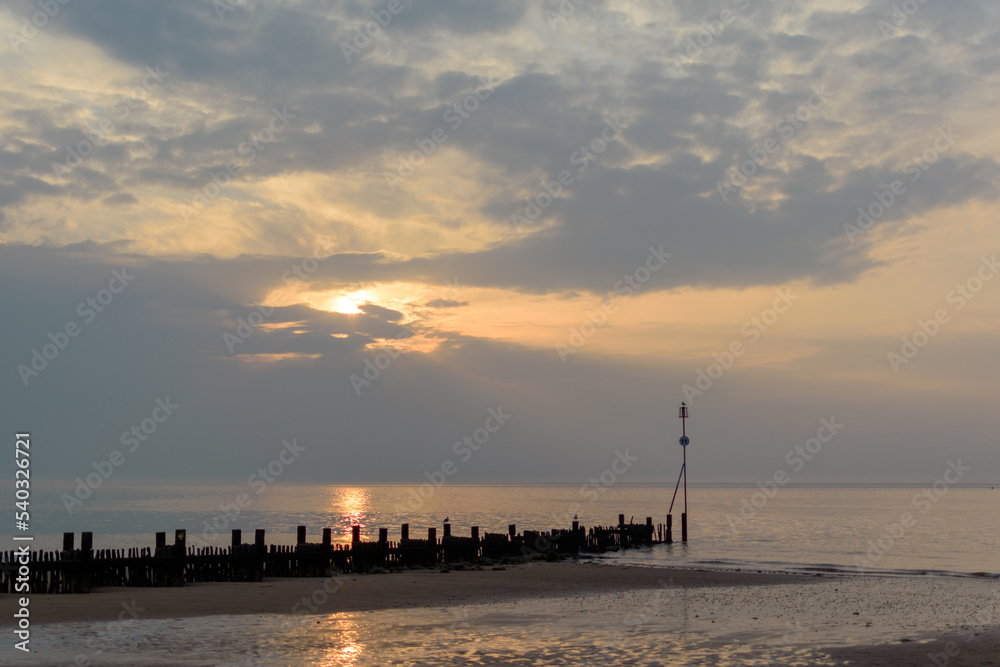 A cloudy sunset on a hazy early summer day on a north Norfolk British beach