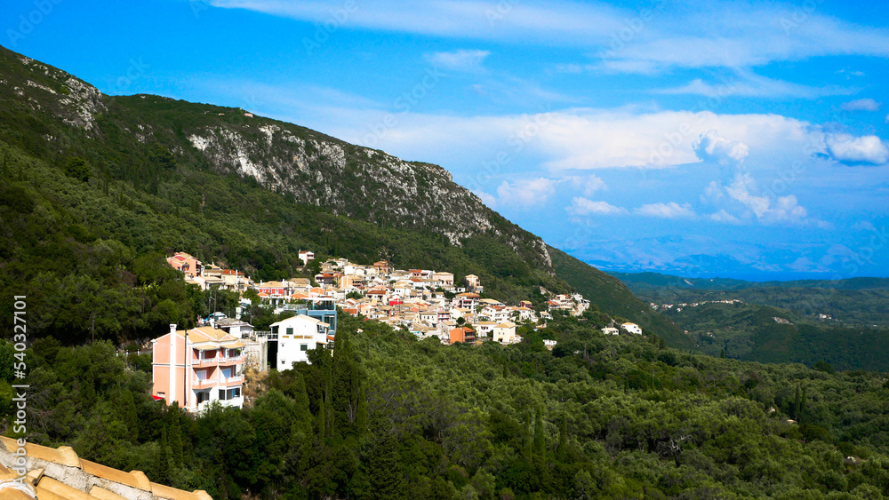 Fototapeta premium A view of a small town located on a mountainside, surrounded by trees 