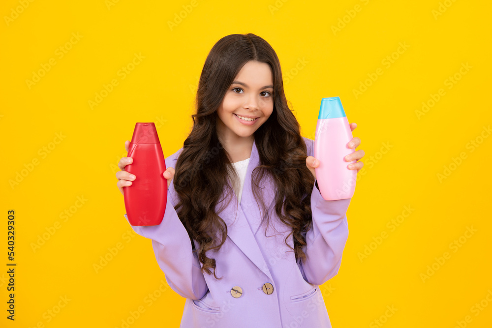 Teenage girl with shampoos conditioners or shower gel. Kids hair care cosmetic product, shampoo bottle. Happy teenager, positive and smiling emotions of teen girl. Teenage girl with shampoos conditioners or shower gel. Kids hair care cosmetic product, shampoo bottle. Happy teenager, positive and smiling emotions of teen girl.