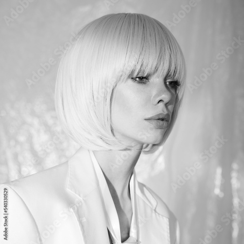 Studio fashion photo of young elegant woman in white men's jacke