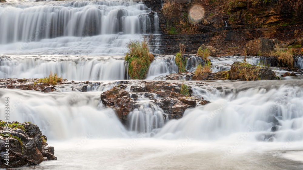 Fototapeta premium Waterfall at Willow River State Park in Hudson Wisconsin in fall