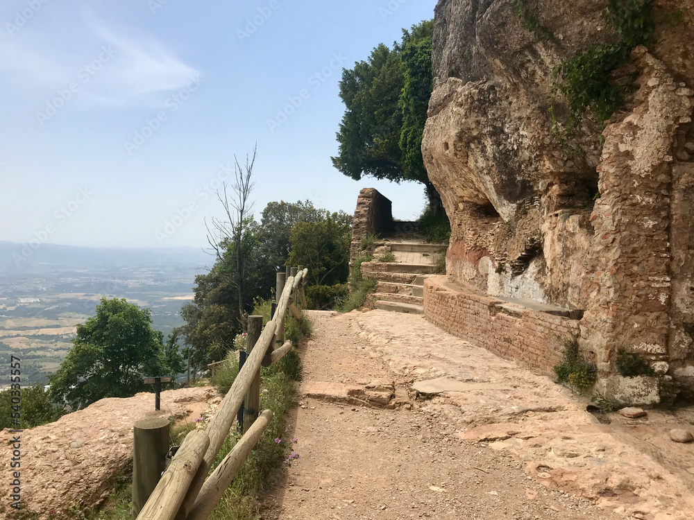 Montserrat, Spain, June 2019 - A dirt path next to a rock wall
