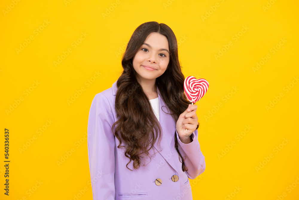 Happy teenager, positive and smiling emotions of teenager girl with lollypop. Candy and sweets for kids. Child eat lollipop popsicle over yellow isolated background. Yummy caramel, candy shop. Happy teenager, positive and smiling emotions of teenager girl with lollypop. Candy and sweets for kids. Child eat lollipop popsicle over yellow isolated background. Yummy caramel, candy shop.