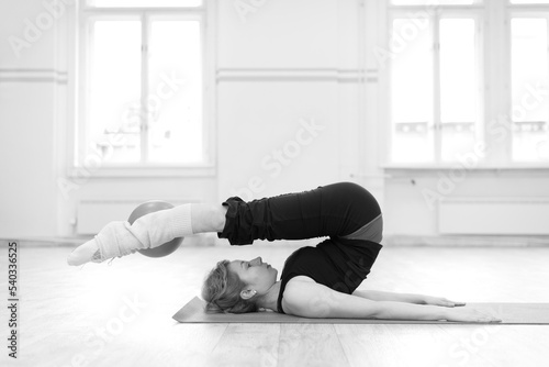 Middle aged woman doing pilates and yoga exercise in the sports gym