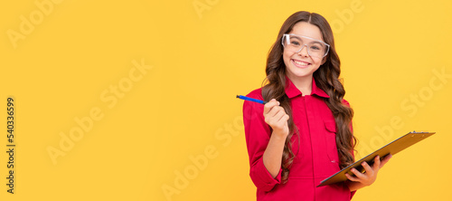 cheerful child girl in glasses making notes, education. Child builder with protective glasses horizontal poster design. Banner header, copy space.